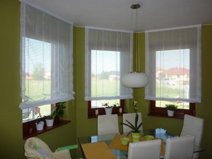 TAKÉ ŘÍMSKÉ ROLETY ZÁCLONOVÉHO TYPU vypadají velice hezky. Elegantní bílá záclona krásně vynikne na pozadí ve výraznějších barvách.