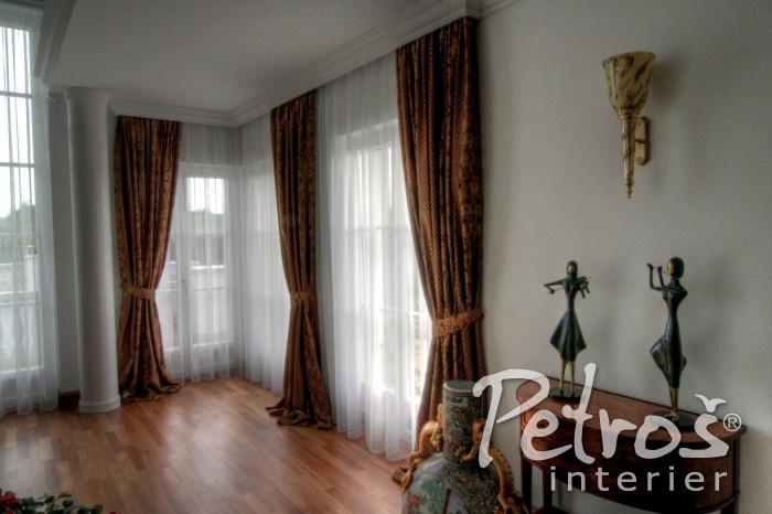 KLASICKÝ STYL INTERIÉRU ve své moderní podobě. I zde mnohdy najdete cenné starožitné kusy nábytku, ty ale zdobí interiér spíše jako solitéry a ostatní zařízení už bývá modernějšího rázu. Do tohoto interiéru designér Radomír Petroš použil na závěsy těžší závěsovou látku s klasickým motivem. Závěsy jsou bohatě nařaseny, na bocích jsou staženy do ledvinkových úvazů a jejich luxusní vzhled ještě zvýrazňuje ležérní délka.