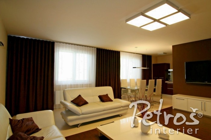 DALŠÍ KRÁSNÁ UKÁZKA INTERIÉRU V MODERNÍM ELEGANT STYLU. Najdete zde lehký luxusní moderní nábytek, designová svítidla, čisté jednoduché linie. Kombinace čokoládové a bílé barvy ještě umocňuje exkluzivitu celého interiéru. Barvám a liniím zůstaly věrné i záclony a závěsy, pro které designér Radomír Petroš zvolil řasení na Wave systém. Elagantní garnýže Square line zavěšené do stropu zde pak působí, jako by se narodily právě pro tento interiér.