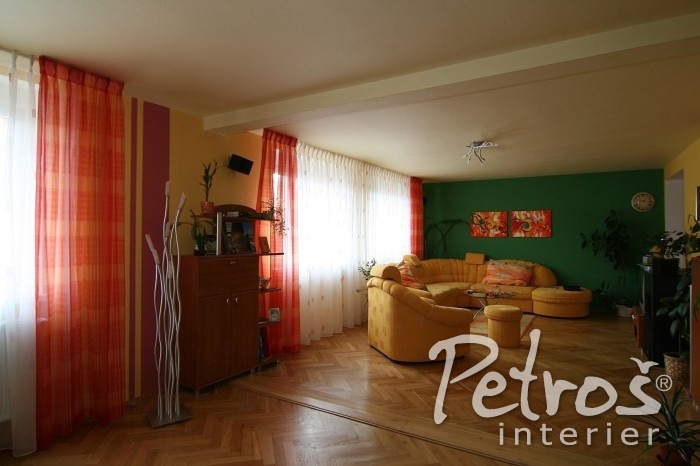 MODERNÍ ELEGANT STYL, TO OVŠEM NEJSOU JEN PASTELOVÉ BARVY. Zde například designér Radomír Petroš majitelům interiéru doporučil lehké závěsy ve svižných oranžově lososových tónech se záclonami s jemným vzorkem ve stejných odstínech jako na závěsech. Záclony a závěsy jsou zde nařaseny technikou Vlámských skladů na háčky Mikroflex a zavěšeny jsou na technických garnýžích. V interiéru jsou použity pestřejší barvy, ale díky jejich citlivému sladění celek působí velmi harmonicky a uceleně.